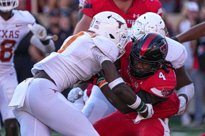 Texas Tech Red Raiders runningback SaRodorick Thompson (4) is tackled by Texas Longhorns players during a game at Jones AT&T Stadium.